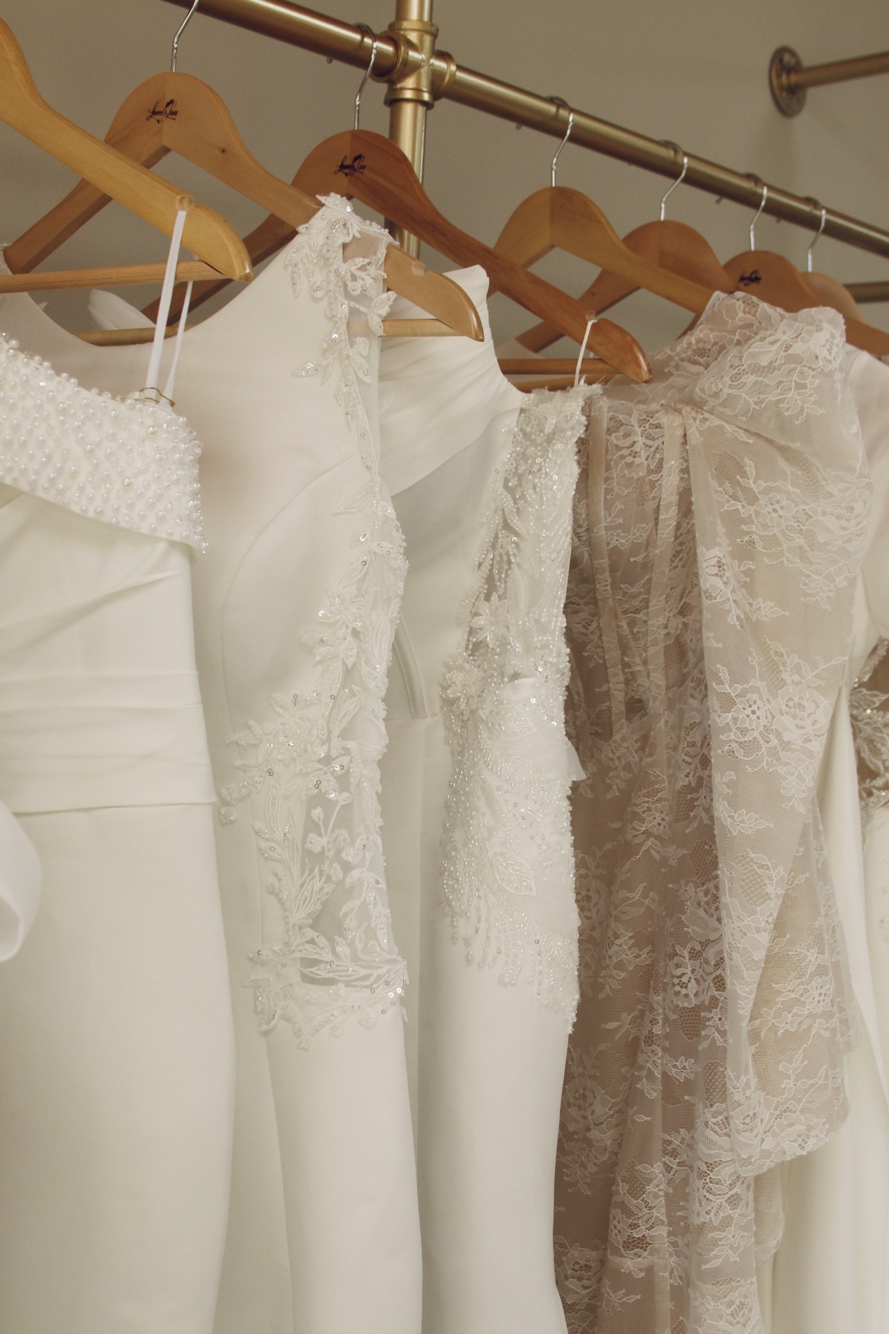 Satin and lace wedding gowns on Laurel and Lace hangers inside our Sandy Springs boutique